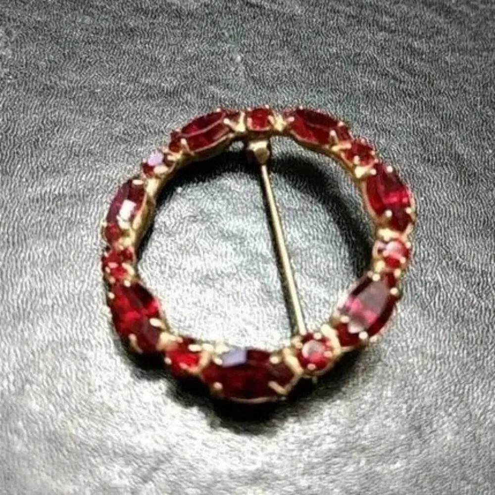 Vintage gold tone round pin w red rhinestones